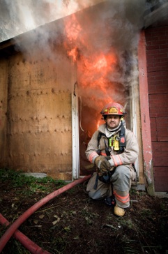 Firefighter posing in front of a fire